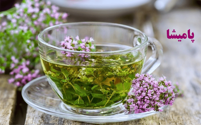 گیاهان دارویی آویشن و گلبابا در کنار یک فنجان دمنوش – مناسب برای سبک زندگی سالم