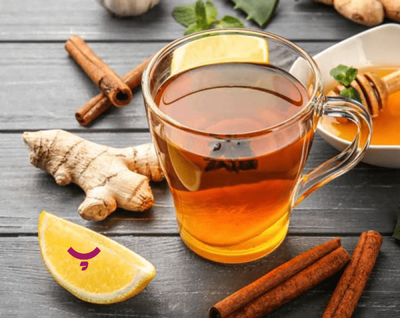 فنجان چای دارچین و زنجبیل در کنار یک ظرف از زنجبیل تازه – راهکار خانگی برای پوست صورت